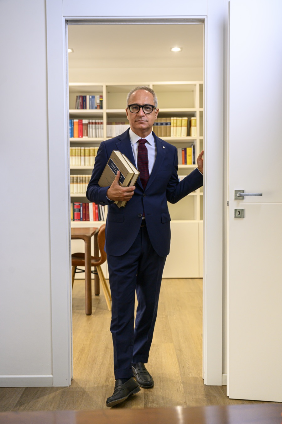 Giovanni Antonio Lampis nella biblioteca dello studio, con i codici